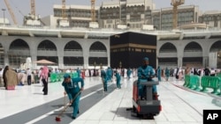 Workers clean the Grand Mosque, during the minor pilgrimage, known as Umrah, in the Muslim holy city of Mecca, Saudi Arabia, Monday, March 2, 2020. 