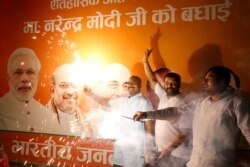 Supporters of India's ruling Bharatiya Janata Party (BJP) light firecrackers and celebrate the government revoking Kashmir's special status, in Lucknow, India, Tuesday, Aug. 6, 2019.