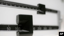 FILE - An April 3, 2018, illustration photo shows a closeup of a beam scale in New York.