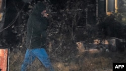 Seorang diplomat Rusia tampak merokok di lahan di mana Australia melarang Rusia untuk kantor keduataan barunya di Canberra, pada 23 Juni 2023. (Foto: AFP/Yoann Cambefort)