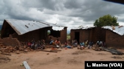 Victims of mob attacks sitting outisde their demolished houses on suspicion that they are withholding rains.