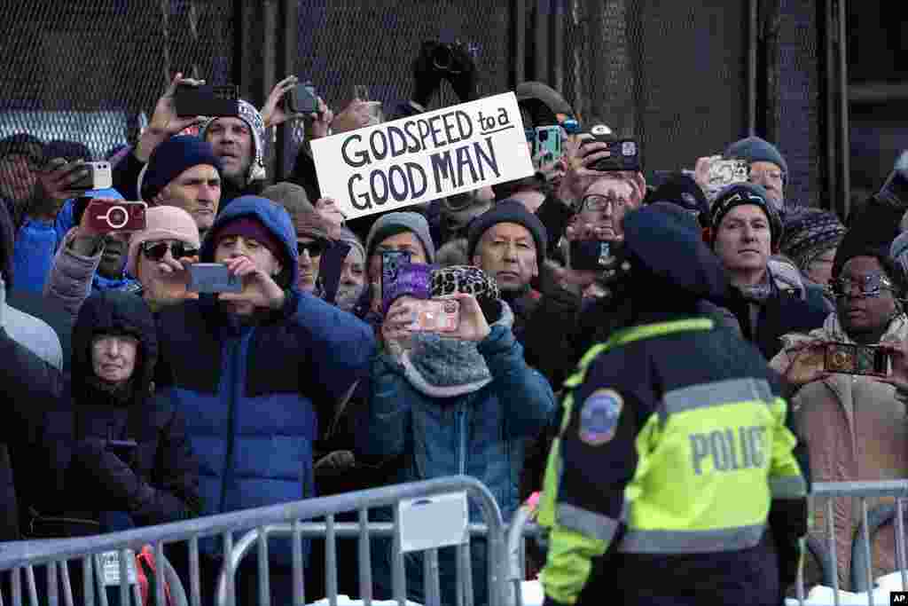 People watch as casket of former President Jimmy Carter passes on a horse-drawn caisson on Pennsylvania Avenue in Washington on its way to the U.S. Capitol, Jan. 7, 2025.
