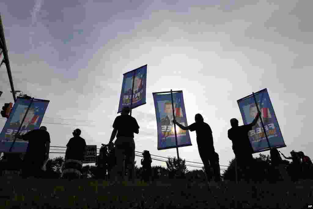 Supporters of Army Pfc. Bradley Manning hold up banners as they protest outside of the gates at Fort Meade, Maryland, August 21, 2013.