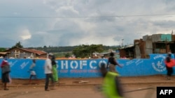 FILE - People walk across a bridge with a message written on the barriers advocating personal efforts to stem the spread of the COVID-19 coronavirus in the Kibera slum, Nairobi, on April 14, 2020. 