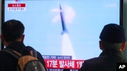People watch TV reporting North Korea's missile test at Seoul Railway Station in Seoul, South Korea, March 4, 2014. 