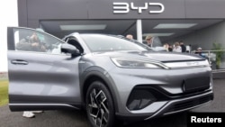 资料照片: 2023年4月28日英国法恩伯勒举行的电动汽车贸易展上，媒体和公众在观看中国汽车制造商比亚迪生产的Atto 3电动运动休旅车