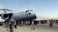 Hundreds of people run alongside a U.S. Air Force C-17 transport plane as it moves down a runway of the international airport, in Kabul, Afghanistan, Aug.16. 2021.