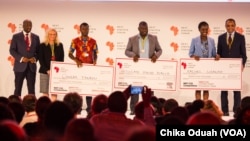 Dr. Conrad Tankou, Rachel Sibande and Dr. Abdoulaye Diallo stand on the stage at NEF holding the $25,000 checks that they won for their innovation prizes.