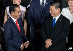 FILE - Indonesian President Joko Widodo, left, speaks to Chinese President Xi Jinping at the G-20 summit on June 28, 2019, in Osaka, Japan. During Widodo's time as president, China became Indonesia’s largest trading partner.
