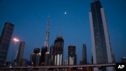 A lone taxi cab rushes down the largely empty 12-lane Sheikh Zayed Road in front of the Burj Khalifa, the world's tallest building, in Dubai, United Arab Emirates, is now under a 24-hour lockdown over the new coronavirus pandemic