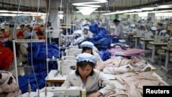 FILE - North Korean employees, shown in December 2013, sew in a South Korean-owned company at the Kaesong industrial park just north of the demilitarized zone. 