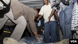 Seorang polisi Kenya memeriksa kantung celana seorang pria yang tewas akibat ledakan granat di Nairobi (10/3).