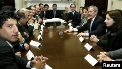 FILE - U.S. President George W. Bush meets with Iraqi Fulbright Scholars, the first to come to the United States since 1990, in the Roosevelt Room of the White House in Washington, Feb. 3, 2004.