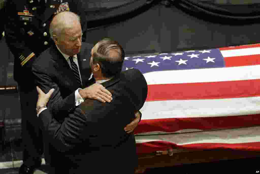 Vice President Joe Biden hugs a mourner as they stand near Beau Biden's casket during a viewing, at Legislative Hall in Dover, Delaware, June 4, 2015.
