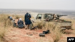FILE - Militants of the Movement for the Salvation of Azawad stand on a dune in the deserted area of the Meneka region in Mali during an anti-jihadist patrol, Feb. 4, 2018.