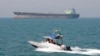 FILE-- In this July 2, 2012 file photo, an Iranian Revolutionary Guard speedboat moves in the Persian Gulf while an oil tanker is seen in background.