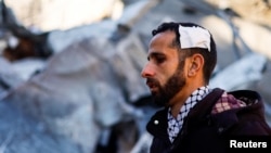 A wounded Palestinian man looks on at the site of an Israeli strike in Rafah, Gaza Strip, on Feb. 3, 2024.