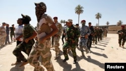 Shi'ite volunteers, who have joined the Iraqi army to fight against militants of the Islamic State, formerly known as the Islamic State in Iraq and the Levant (ISIL), march during training in Baghdad, July 9, 2014. 