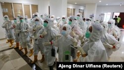 Petugas kesehatan yang mengenakan alat pelindung diri (APD) bersiap untuk merawat pasien di rumah sakit darurat COVID-19 di Wisma Atlet, Jakarta, 26 Januari 2021. (REUTERS/Ajeng Dinar Ulfiana)