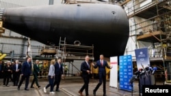 Урядовці з країн, що надають зброю Україні через фонд, який очолює Британія, відвідують суднобудівний завод Osborne Naval Shipyard в Аделаїді, Австралія, 22 березня 2024 року. AAP Image/Matt Turner via REUTERS