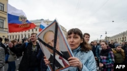 FILE - Opposition activists participate in a rally against Russian President Vladimir Putin, in Saint Petersburg, Russia, May 5, 2018.