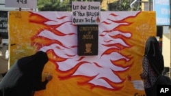 Indian Muslim women write on a poster during a protest against a new citizenship law that opponents say threatens India's secular identity, in Mumbai, India, Jan. 30, 2020.