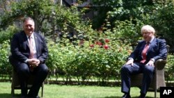 Britain's Prime Minister Boris Johnson, right, welcomes U.S. Secretary of State Mike Pompeo to Downing Street, London, ahead of a private meeting, July 21, 2020. 
