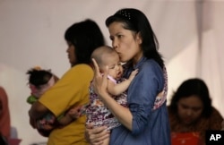 Para ibu sedang membawa anak-anak mereka untuk vaksinasi rutin di Tambun, Jawa Barat, 15 Juli 2016. (Foto: Achmad Ibrahim/AP Photo)
