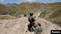 FILE - An Afghan border policeman is seen patrolling a section of the frontier between Afghanistan and Pakistan.