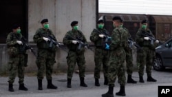 Serbian soldiers patrol around the center for refugees in Sid, about 100 kilometers west of Belgrade, Serbia, May 16, 2020. 