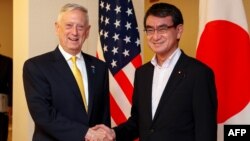 U.S. Secretary of Defense James Mattis, left, shakes hands with Japanese Foreign Minister Taro Kono at the Foreign Ministry in Tokyo, June 29, 2018.