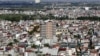 FILE - An apartment building under construction (C) is seen surrounded by older residential houses in Hanoi July 1, 2015.