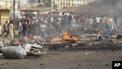 FILE - People gather at the site of a bomb explosion at a road in Kaduna, Nigeria, April 8, 2012.