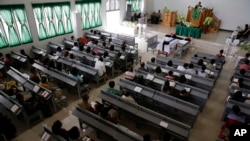 Christians listen to the priest inside a church at the earthquake and tsunami-hit town of Palu, Central Sulawesi, Indonesia, Oct. 7, 2018. 