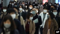 A station passageway is crowded with face mask wearing commuters during a rush hour Monday, April 20, 2020, in Tokyo. Japan's Prime Minister Shinzo Abe expanded a state of emergency to all of Japan from just Tokyo and other urban areas as the virus…
