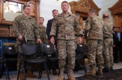 FILE - U.S. Army General Scott Miller, center, commander of U.S. and NATO troops in Afghanistan, is seen at the presidential palace in Kabul, Afghanistan, Nov. 6, 2018.