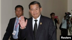 Prime Minister Hun Sen gestures as he arrives at the National Assembly for a meeting in central Phnom Penh, Sept. 24, 2013.