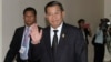 Prime Minister Hun Sen gestures as he arrives at the National Assembly for a meeting in central Phnom Penh, Sept. 24, 2013.