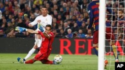 Cristiano Ronaldo marque le deuxième but du Real Madrid battant le gardien de Barcelone Claudio Bravo lors d'un match de football de La Liga espagnole surnommé «el clasico» opposant le Barcelone au Real Madrid, au stade Camp Nou à Barcelone, Espagne, 2 avril 2016.