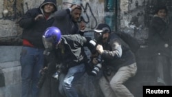 Photographers cower as protesters throw stones towards riot police along Sheikh Rihan street near Tahrir Square in Cairo January 25, 2013.
