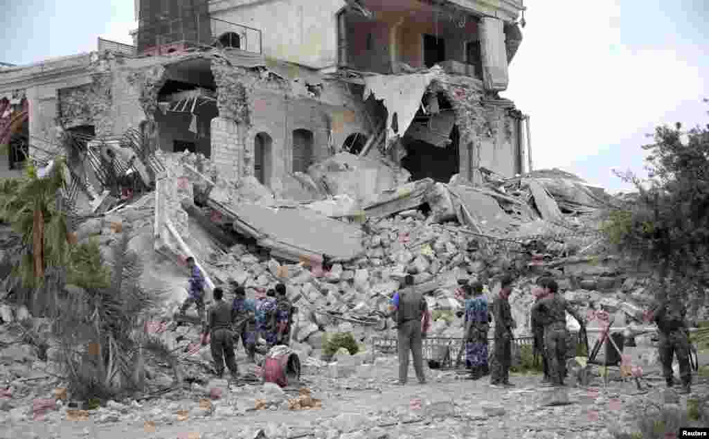 Forces loyal to President Bashar al-Assad stand on debris of a hotel used by al-Assad&#39;s forces, in historic Aleppo May 8, 2014.