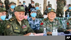 Russian Defense Minister Sergei Shoigu, L, and Chinese Defense Minister Wei Fenghe watch a joint military exercise held in the Ningxia Hui Autonomous Region in northwestern China, Aug. 13, 2021. (Russian Defense Ministry Press Service/Handout)