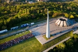 People line up to lay flowers at the monument to the victims of mass killings by Ottoman Turks, to commemorate the 106th anniversary of the massacre, in Yerevan, Armenia, April 24, 2021.