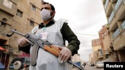 A security man wearing a protective mask stands on a street during a 24-hour curfew amid concerns about the spread of the coronavirus disease (COVID-19), in Sanaa, Yemen May 6, 2020.