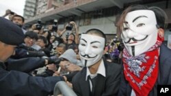 Pro-democracy demonstrators wearing Anonymous masks, scuffle with police during a protest against the Chinese government&#39;s meddling into the Hong Kong&#39;s chief executive election, in Hong Kong, April 1, 2012.