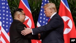 FILE - U.S. President Donald Trump shakes hands with North Korea leader Kim Jong Un at the Capella resort on Sentosa Island, June 12, 2018, in Singapore.