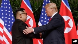 U. S. President Donald Trump shakes hands with North Korea leader Kim Jong Un at the Capella resort on Sentosa Island, June 12, 2018 in Singapore.