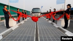 Sebuah kendaraan di jalur panel surya saat peresmian di Jinan, Provinsi Shandong, China, 28 Desember 2017. (Foto: Reuters)