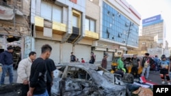 Iraqis gather at the site of a bomb explosion near Baghdad's Tahrir Square, Nov. 16, 2019.
