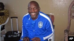 FILE - Liberian soccer star George Weah smiles inside a room in Monrovia, Liberia, Aug. 10, 2014. 